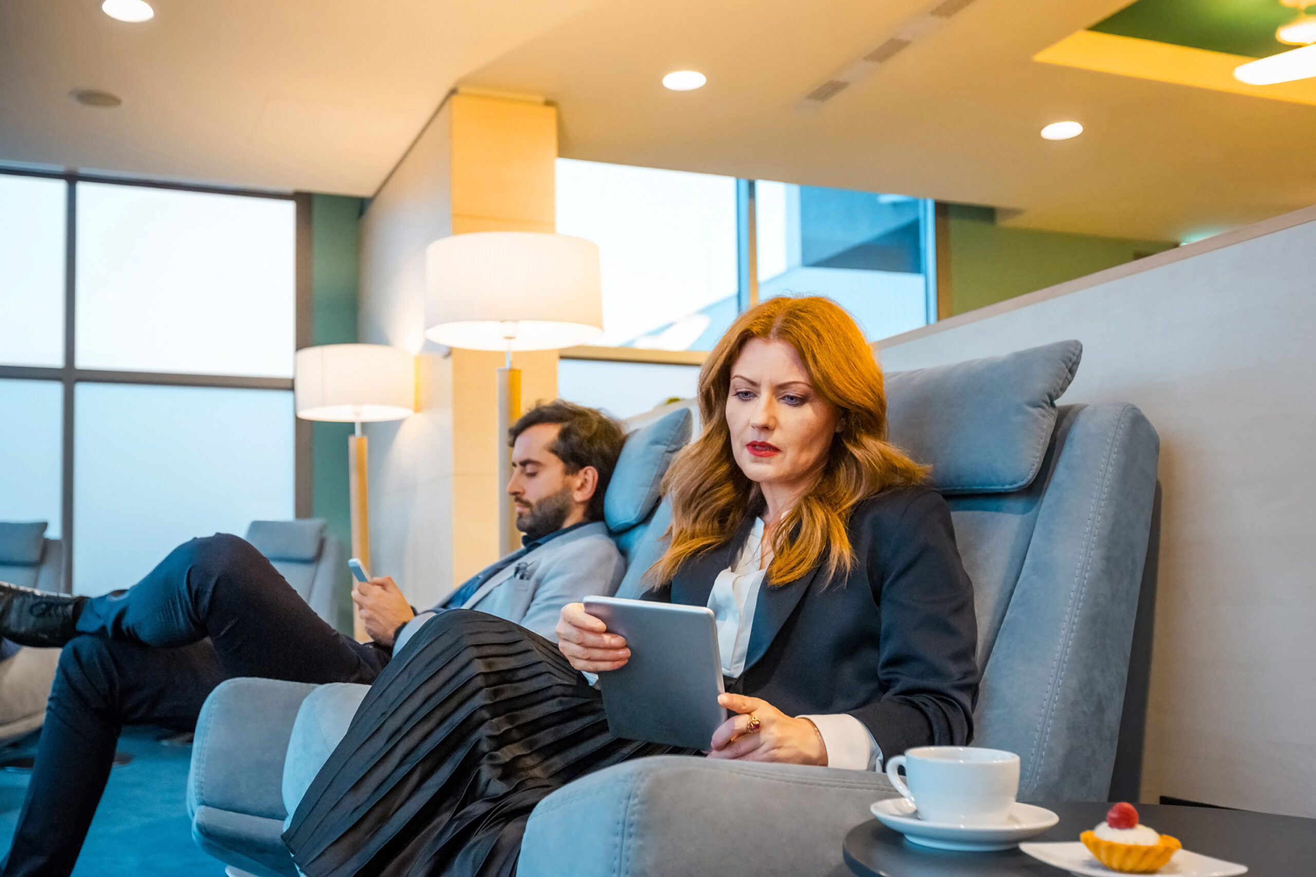 Coworkers using technologies at airport lounge